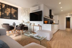 a living room with a couch and a table at Luxury Penthouse with Jacuzzi & Large Terraces by Passeig de Gràcia in Barcelona