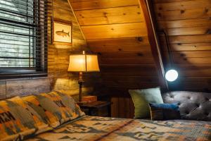 a bedroom with a bed and a lamp and wooden walls at The Refugio #2552 in Big Bear Lake +82 photos