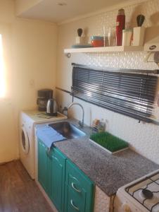 una cocina con fregadero y lavadora en Casa Gregores 2, en Gobernador Gregores