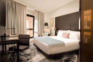 a hotel room with a bed and a desk at art'otel Rome Via Veneto in Rome