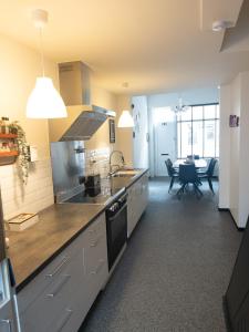 een keuken met een spoelbak en een fornuis bovenste oven bij Little gate in Ieper