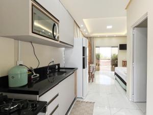 a kitchen with a sink and a microwave at Loft Sol e Mar Exclusivo em Bombinhas 50m da praia in Bombinhas