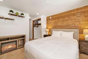 a bedroom with a white bed and a fireplace at Lily's Bear Cabin #2544 in Big Bear Lake