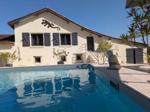 a house with a teddy bear sitting next to a swimming pool at Gîte - le temps d'une pause in Sauveterre