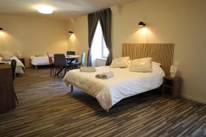 a hotel room with a bed and a table and chairs at Le relais de poste in Ally