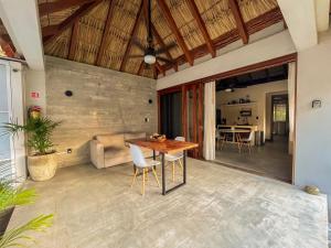 a patio with a wooden table and chairs at Paraíso del Surf, A 50m de las Olas Perfectas, AC, Starlink, Piscina, La Saladita surf in La Salada
