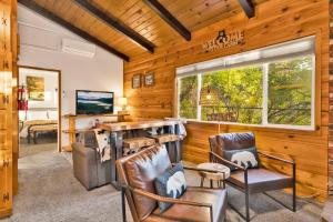 ein Wohnzimmer mit Stühlen und einem Tisch und einem Fenster in der Unterkunft Orchard Family Cabin #2560 in Big Bear Lake