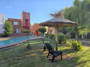 two black chairs and an umbrella in a yard at La Margarita Aparts - Solo 2 Pax in Mina Clavero +3 photos
