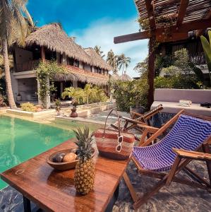 a table and chairs next to a swimming pool at Paraíso del Surf, A 50m de las Olas Perfectas, AC, Starlink, Piscina, La Saladita surf in La Salada