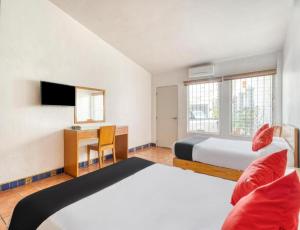 a bedroom with a bed and a desk and a bed at Hotel Arana Tonalá in Guadalajara