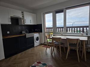 a kitchen with a table and chairs and a window at Apartament Portowy Mewy Dwie in Hel