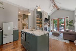 a kitchen with green cabinets and a living room at Elledot Cottage in Summerville