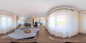 a living room with a table and two large windows at Villa Morfi 1 in Alexandroupoli