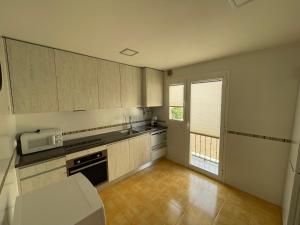 an empty kitchen with a sink and a microwave at Aires de Daimiel in Daimiel