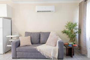 a living room with a gray couch and a table at Azorean Stays T1-Relaxing 1-Bedroom Retreat Near São Miguel Highlights in Lomba da Cruz