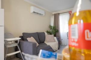 a living room with a gray couch and a table at Azorean Stays T1-Relaxing 1-Bedroom Retreat Near São Miguel Highlights in Lomba da Cruz +21 photos