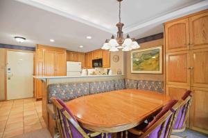 a dining room with a wooden table and a kitchen at Lodge Tower 594 One Bedroom Residence in Vail +30 photos