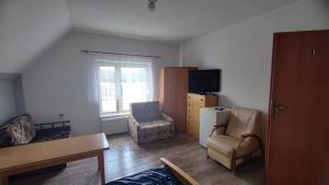 a living room with a couch and a chair at Tarczyny in Lidzbark