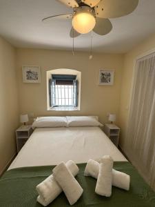 una camera da letto con un letto grande con due asciugamani sopra di Casa Castillo Vejer a Vejer de la Frontera