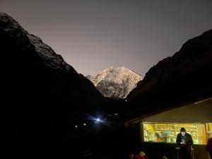 a man standing in front of a mountain at night at Chaullay Star Domes in Colcapampa