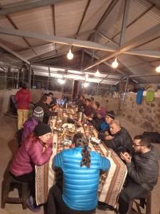 a group of people sitting at tables in a restaurant at Chaullay Star Domes in Colcapampa