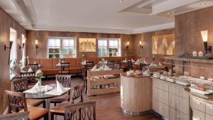 ein Restaurant mit Holzwänden und Tischen und Stühlen in der Unterkunft Der Romantik-Hof Greetsiel in Greetsiel