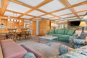 a living room with a green couch and a table at Lodge Tower 599 One Bedroom Residence in Vail