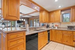 a large kitchen with wooden cabinets and a sink at Lodge Tower 599 One Bedroom Residence in Vail