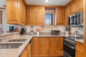a kitchen with wooden cabinets and stainless steel appliances at Lodge Tower 599 One Bedroom Residence in Vail
