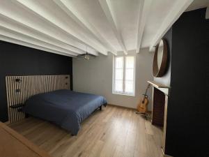 a bedroom with a bed and a guitar in it at Maison du bonheur in Combres +14 photos