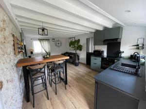 a kitchen with a wooden table and a counter top at Maison du bonheur in Combres