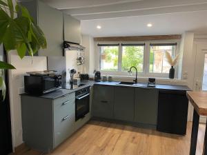 a kitchen with a sink and a stove top oven at Maison du bonheur in Combres +11 photos