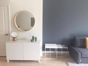 a living room with a white cabinet and a mirror at Modern Bedroom In Great Condo! Beach Pass Incl! in Boynton Beach