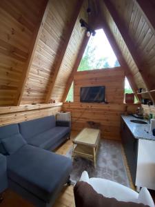 a living room with a blue couch in a log cabin at Akorya bungalov in Ardeşen