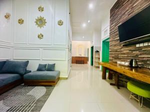 a living room with a blue couch and a tv at Cliff House Bali With Private Pool in Sukasada