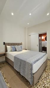 a bedroom with a large bed with blue pillows at Serenata in Corfu Town
