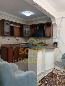 una cocina con encimera y algunas sillas azules en Sonic-Holidayhomes, en Alejandría