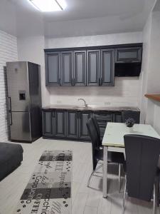 a kitchen with a table and a refrigerator at Віта Поляна ,Карпати,квартира , апартаменти in Polyana +4 photos