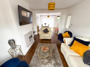 a living room with a couch and a tv at Bassetts House - Contractor ready! in Farnborough