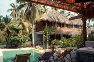 a resort with a pool and chairs and a building at Villa Rincón del surf, 50m spot surf, AC, Starlink, Alberca, Terraza, La Saladita in La Majahua