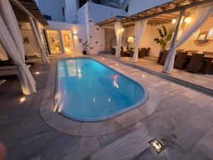 a swimming pool in the middle of a patio at Renthousetinos in Tinos