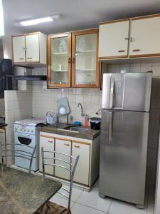 a kitchen with a stainless steel refrigerator and cabinets at Apartamento Caldas Novas in Caldas Novas