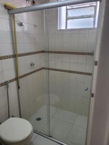 a bathroom with a shower with a toilet and a window at Apartamento Caldas Novas in Caldas Novas +3 photos