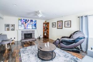 Una sala de estar con una silla y una chimenea. en Swinton, en North Hills