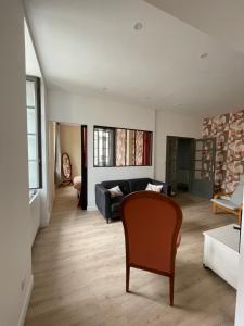 un soggiorno con un divano e una poltrona di Maison Côté Halle L'Artiste a Saint-Flour