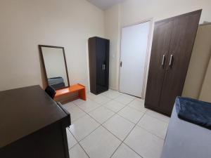 an empty room with a mirror and a room with a door at Casa no centro! in Campo Mourão