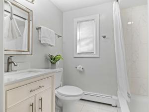 a white bathroom with a toilet and a shower at Boston 4BR Home with Parking BBQ Fire in Somerville +33 photos