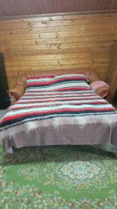 a bed with a colorful blanket on top of it at Casa Leo in Cristur
