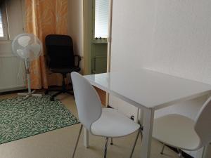 a room with a white table and chairs and a fan at Flexible Myllykallio in Jyväskylä