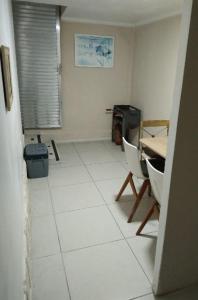 een kamer met een tafel, stoelen en een witte vloer bij New Casa Studio Mega - Reformado in Santos +25 foto's